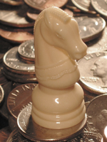 Chess knight sitting on coins